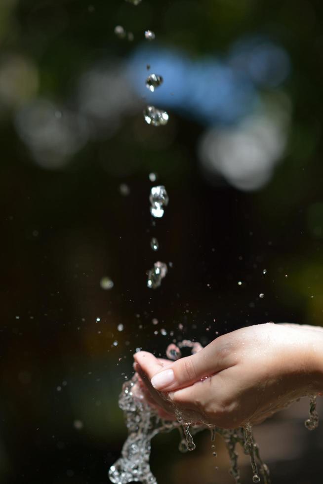 fluxo de água na mão da mulher foto