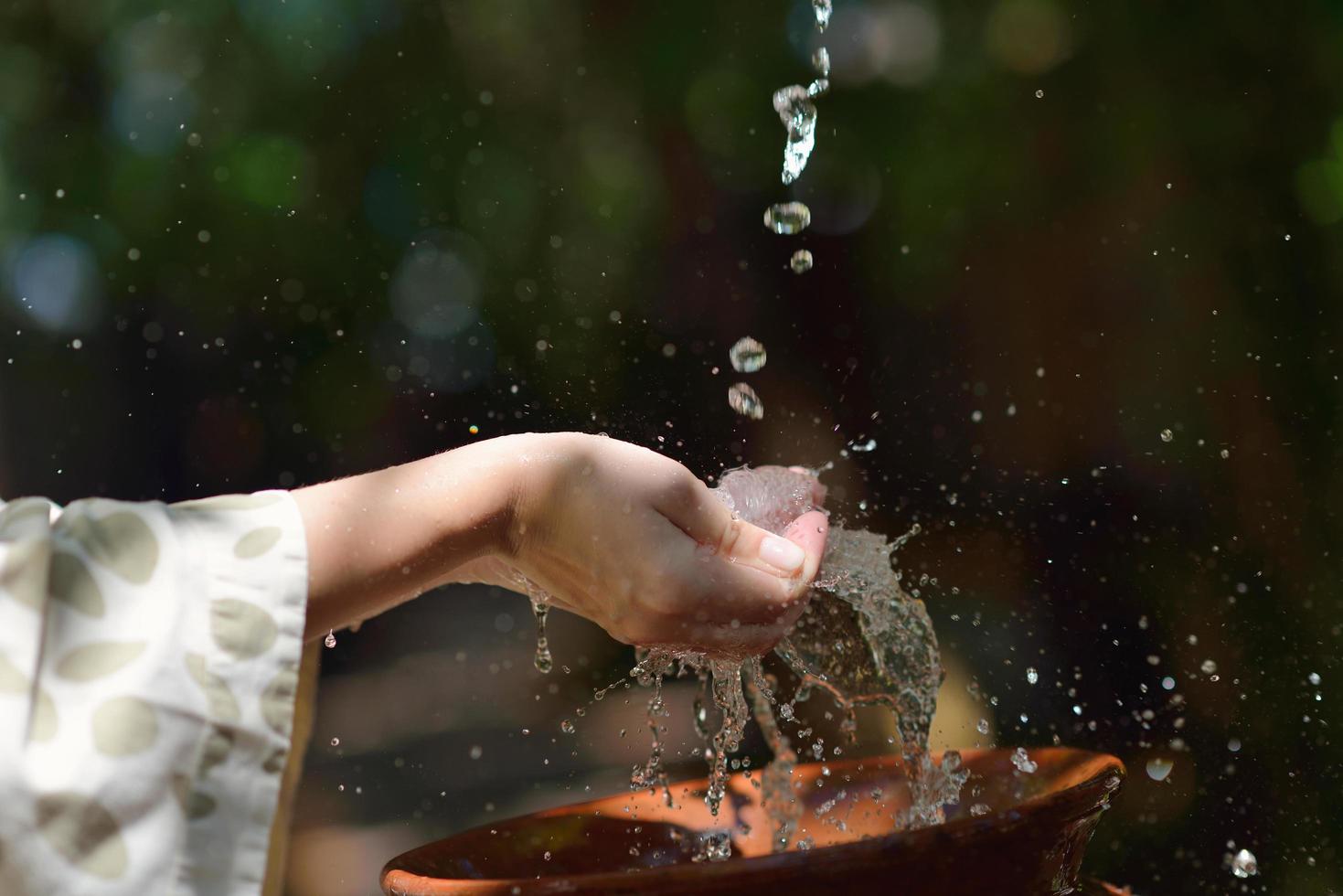 espirrando água fresca nas mãos da mulher foto