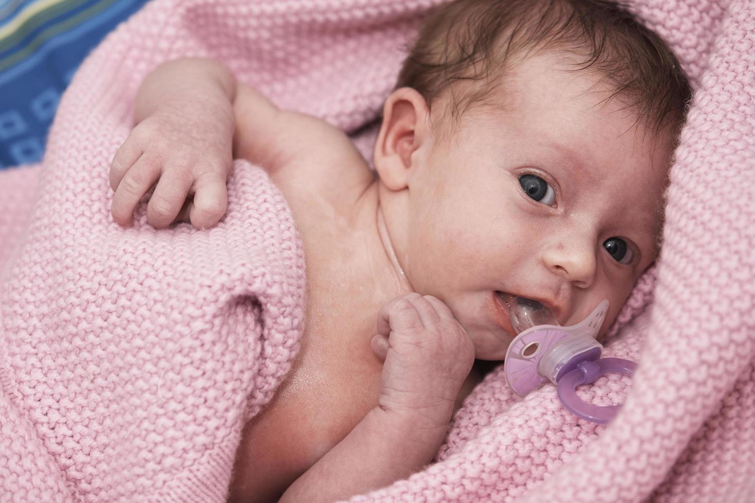 bebê recém-nascido de um mês dormindo na cama foto