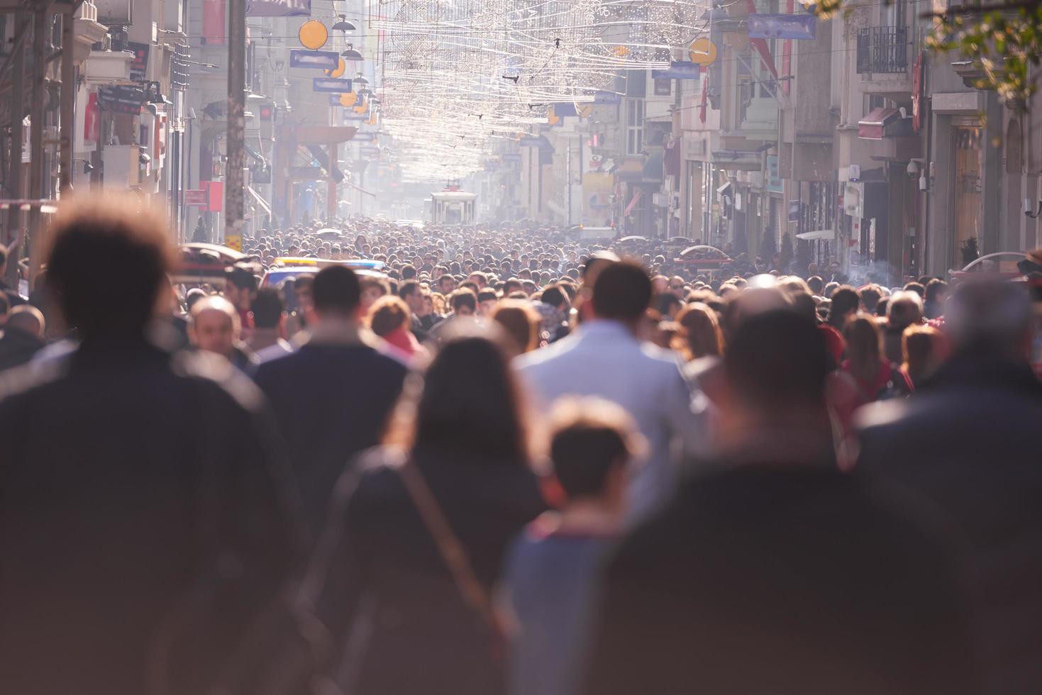 multidão de pessoas andando na rua foto