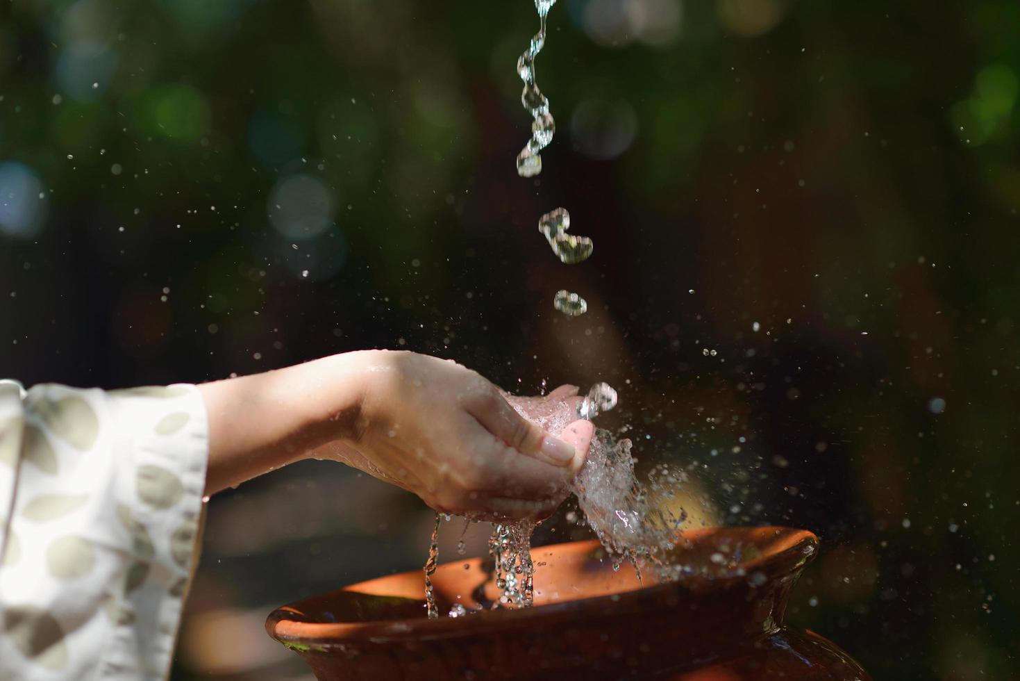 espirrando água fresca nas mãos da mulher foto