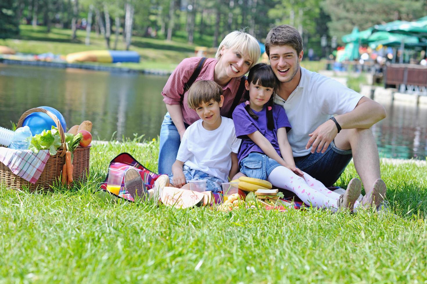 família feliz jogando juntos em um piquenique ao ar livre foto