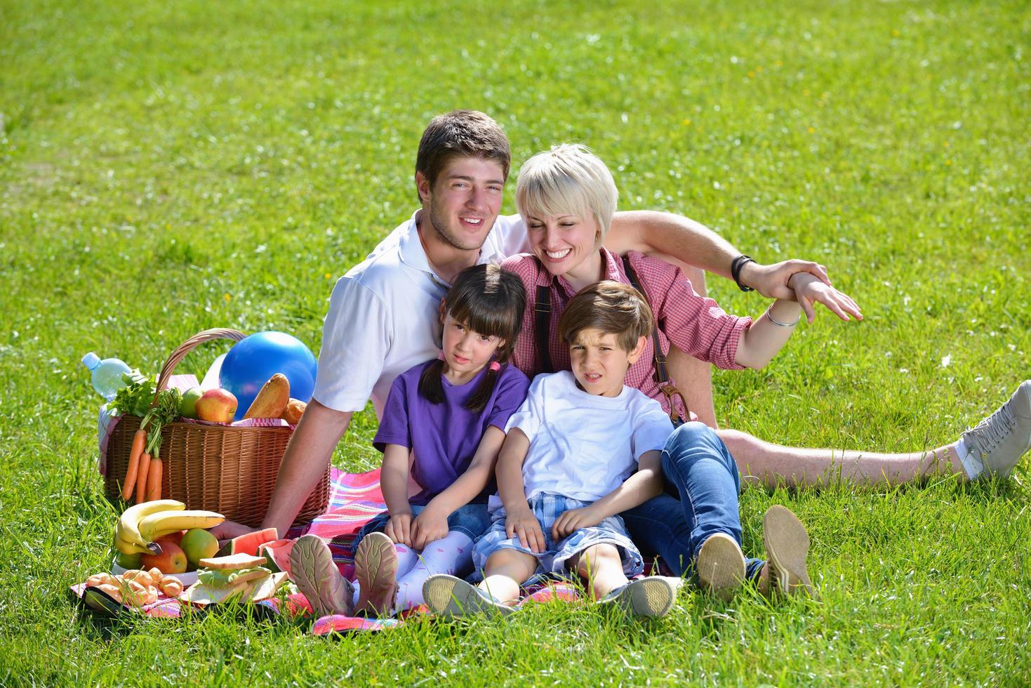 família feliz jogando juntos em um piquenique ao ar livre foto