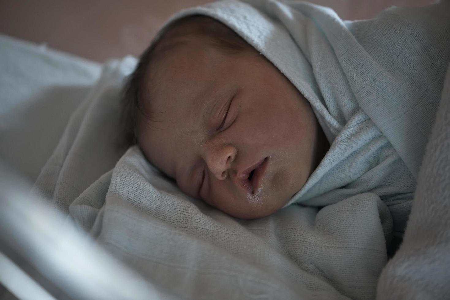 bebê recém-nascido dormindo na cama no hospital foto