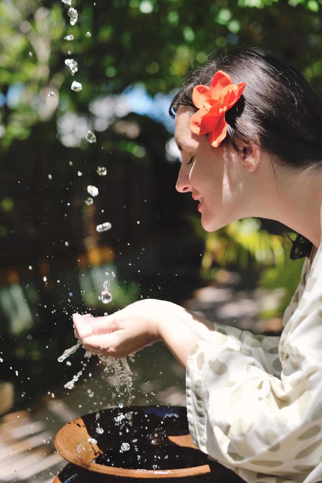 espirrando água fresca nas mãos da mulher foto