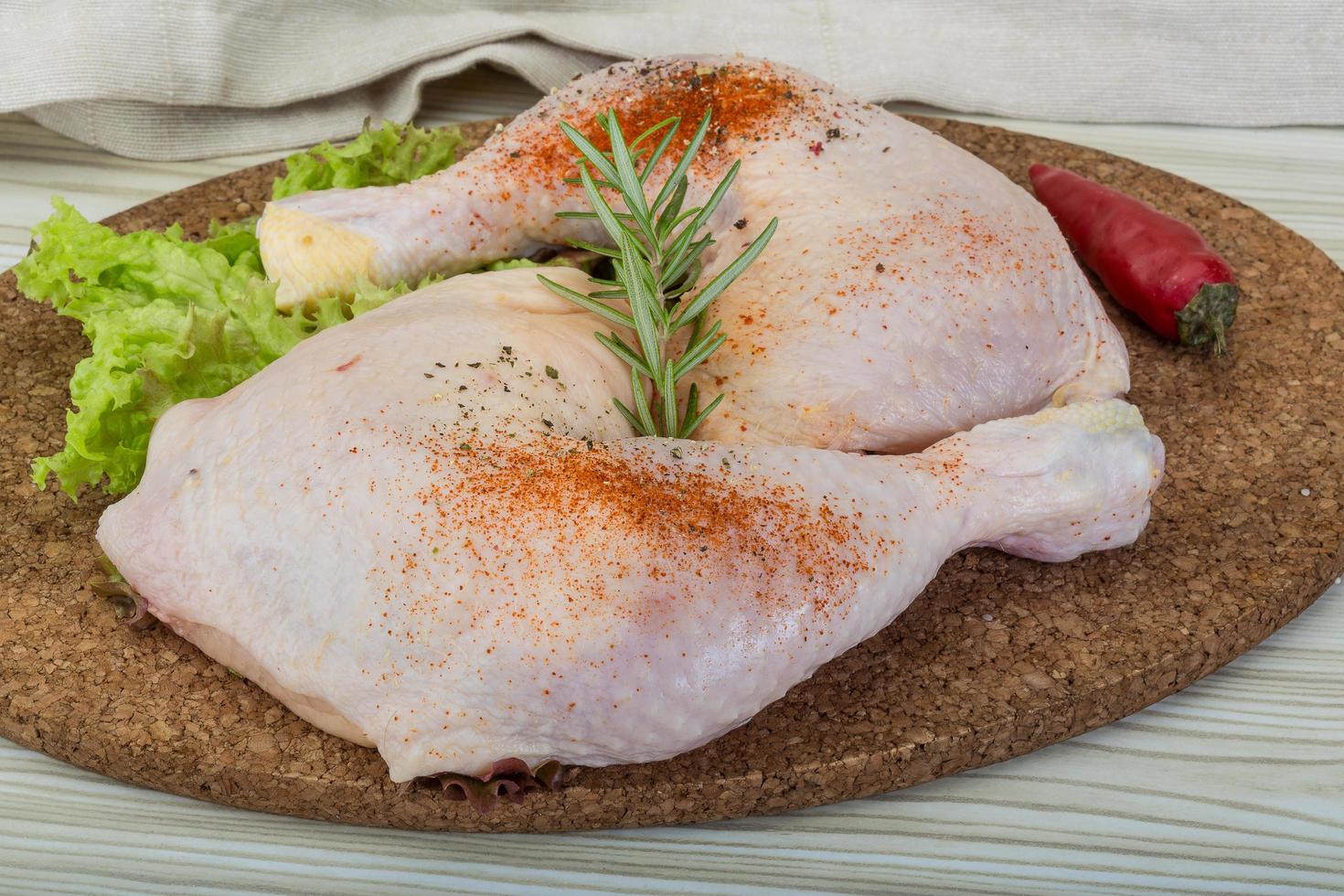 coxa de frango na tábua de madeira e fundo de madeira foto