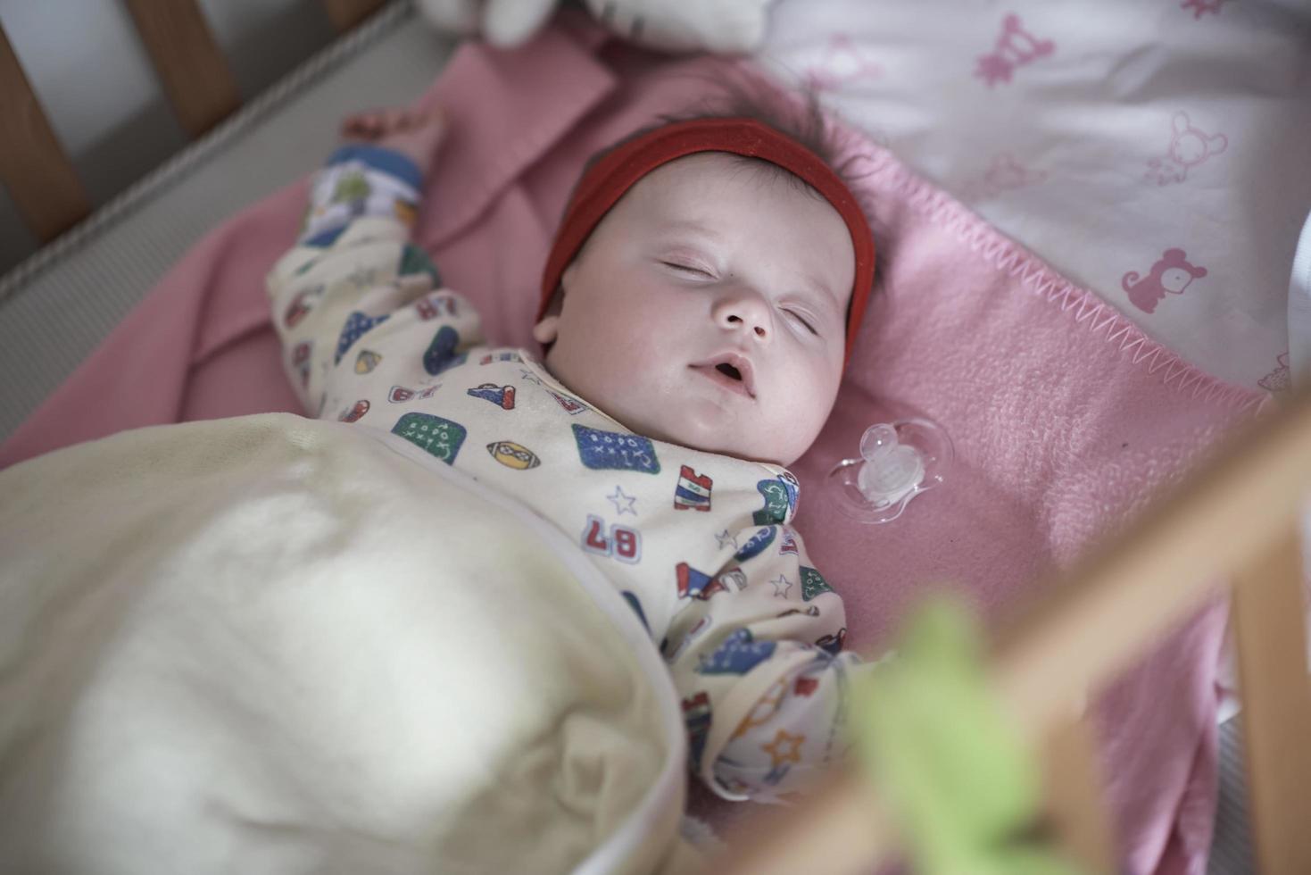 bebê recém-nascido dormindo em casa na cama foto