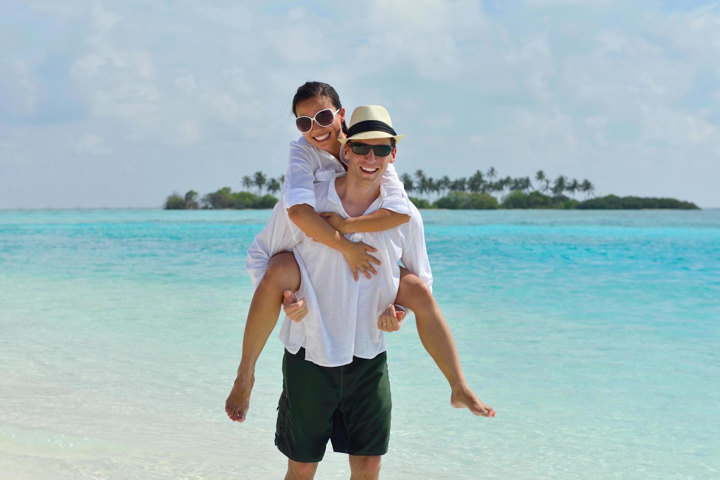 feliz casal jovem se divertir na praia foto