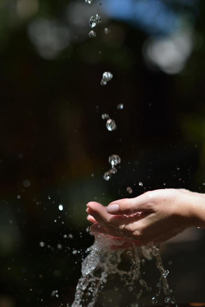 fluxo de água na mão da mulher foto