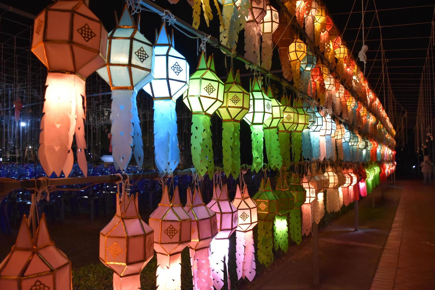 lanternas de papel lindamente moldadas e coloridas são penduradas na frente de um pagode para adorar o senhor buda em um templo no norte da tailândia. foto