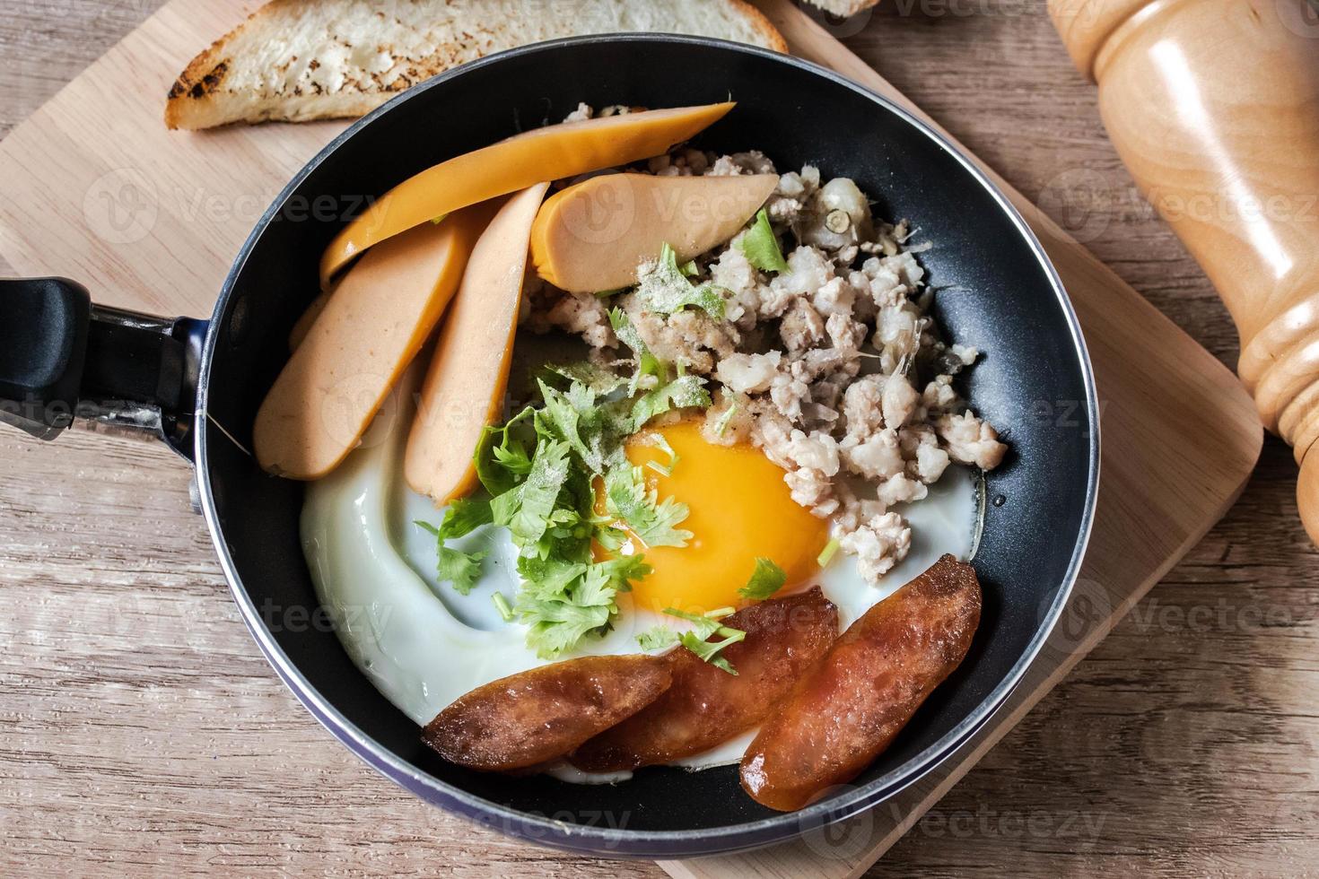 café da manhã inglês com ovo frito com porco picado e salsicha tailandesa chamada kai kara servido em uma panela pequena foto