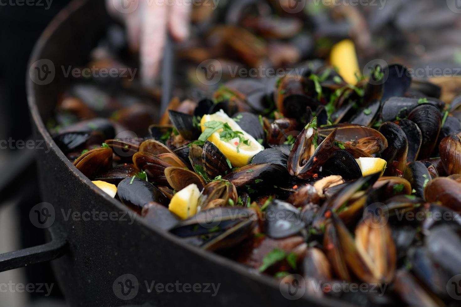 close-up de mexilhões cozidos em um festival de comida de rua, pronto para comer frutos do mar fotografados com foco suave foto