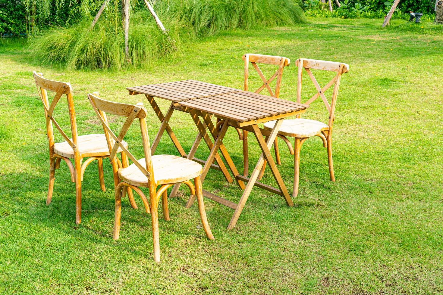 mesa e cadeira de madeira no jardim foto