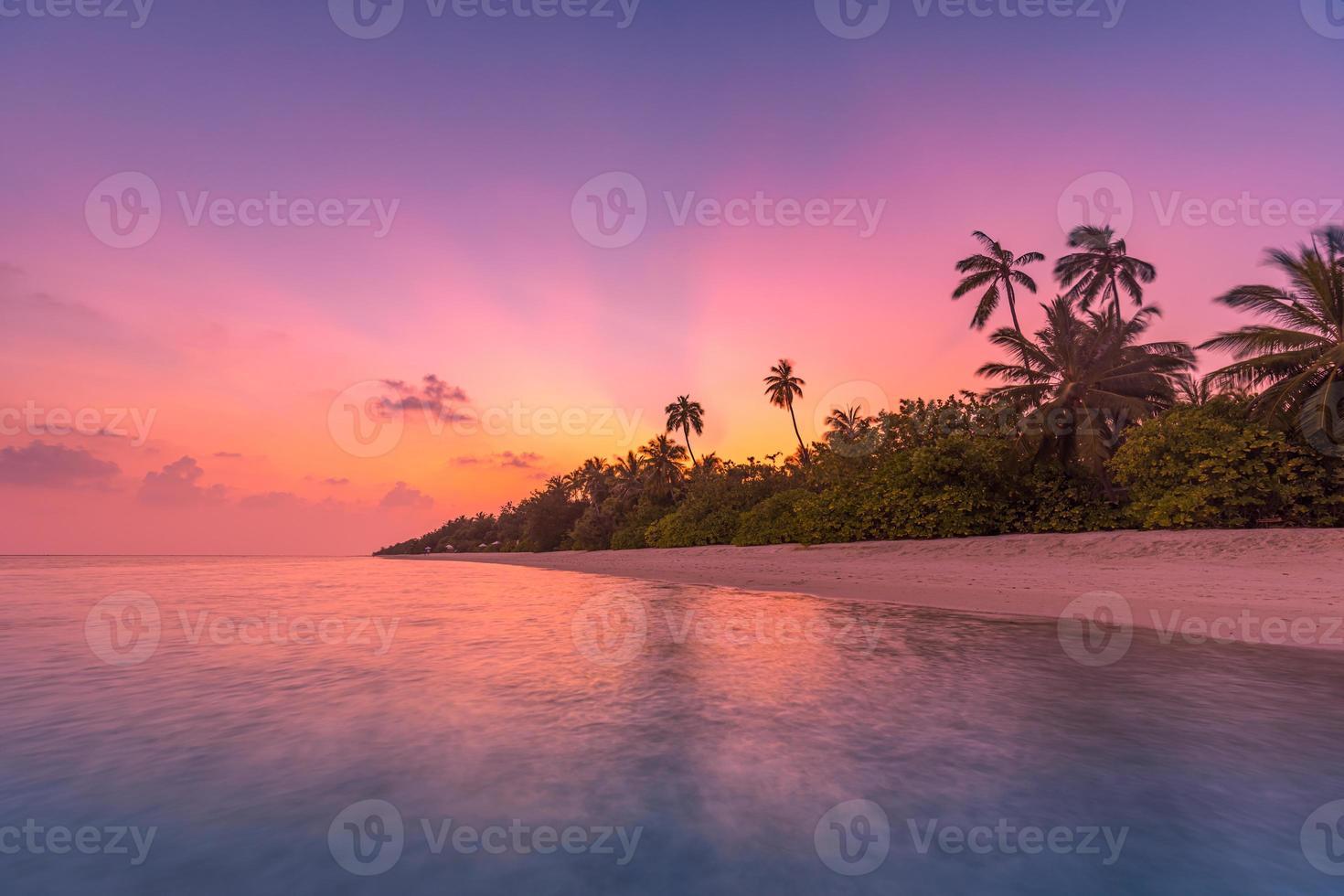 palmeiras na praia tropical, pôr do sol incrível, costa da ilha tropical. raios de sol, sonho romântico paisagem de praia exótica. palmeiras, horizonte de mar de lagoa calma. foto