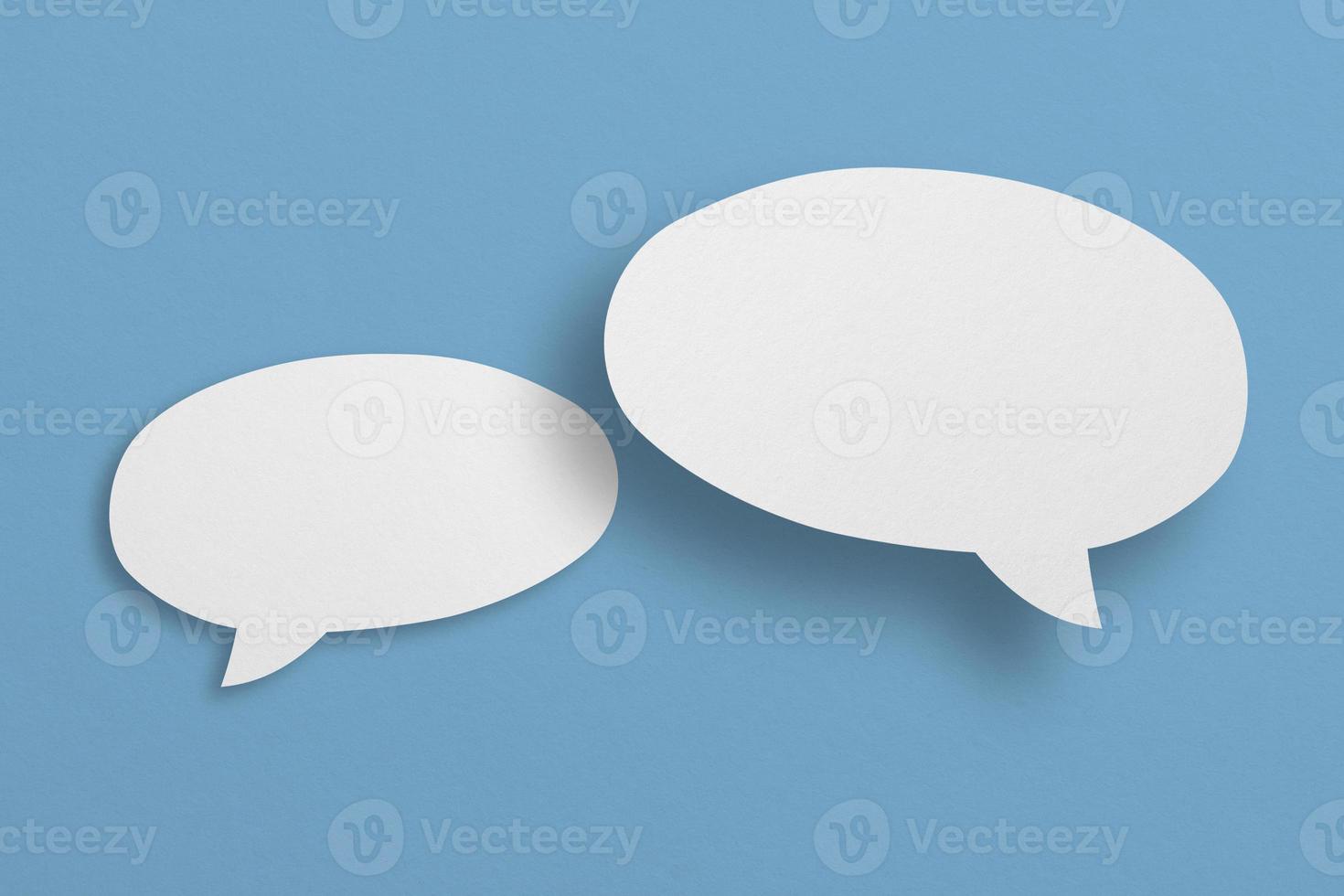 papel branco com bolhas do discurso isoladas em bolhas de comunicação de fundo azul foto