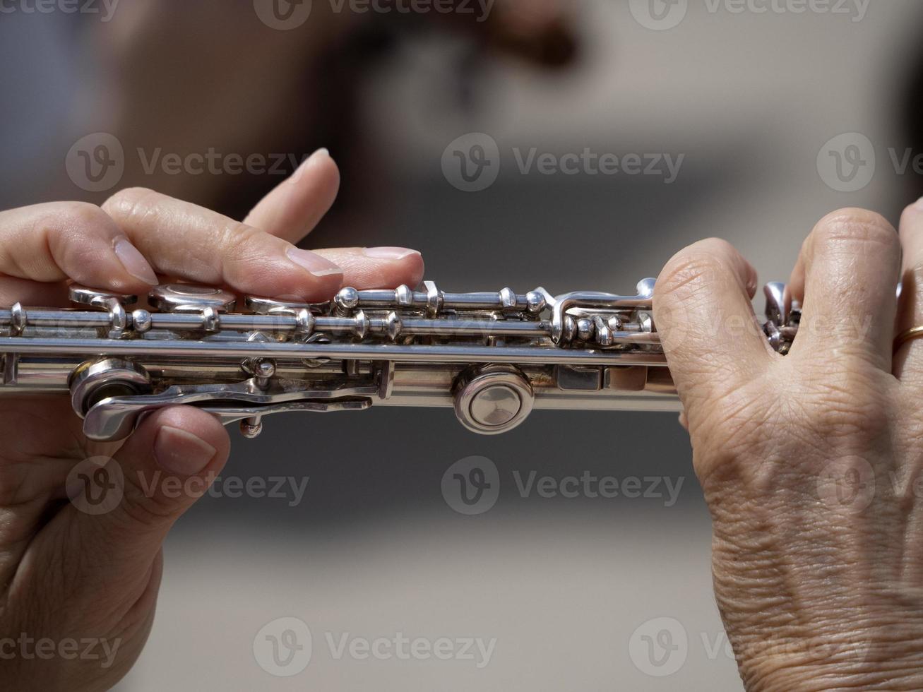 mãos tocando flauta transversal foto