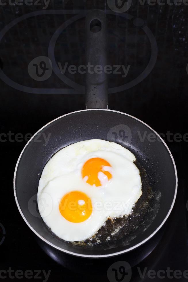 dois ovos fritos preparados na frigideira foto