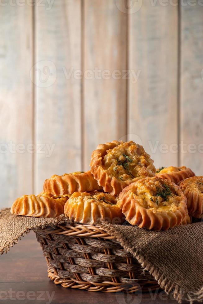 cesta com muffins frescos em fundo de madeira. bolos caseiros com legumes e queijo. receita para o prato sazonal de outono. foto
