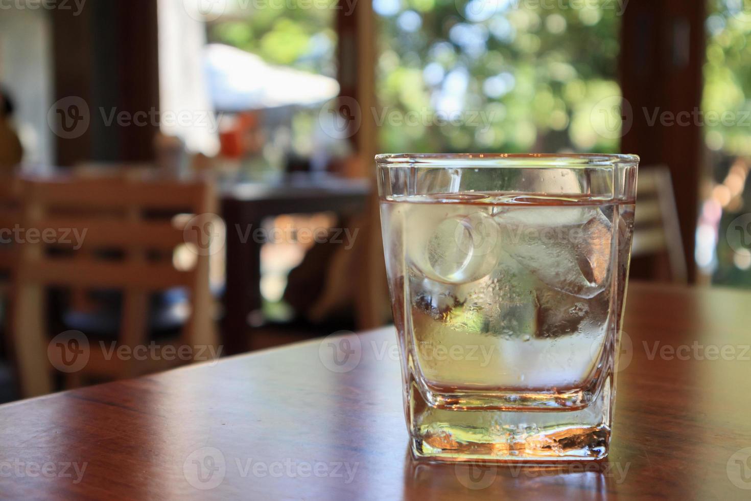 copo de água na mesa de madeira no restaurante foto