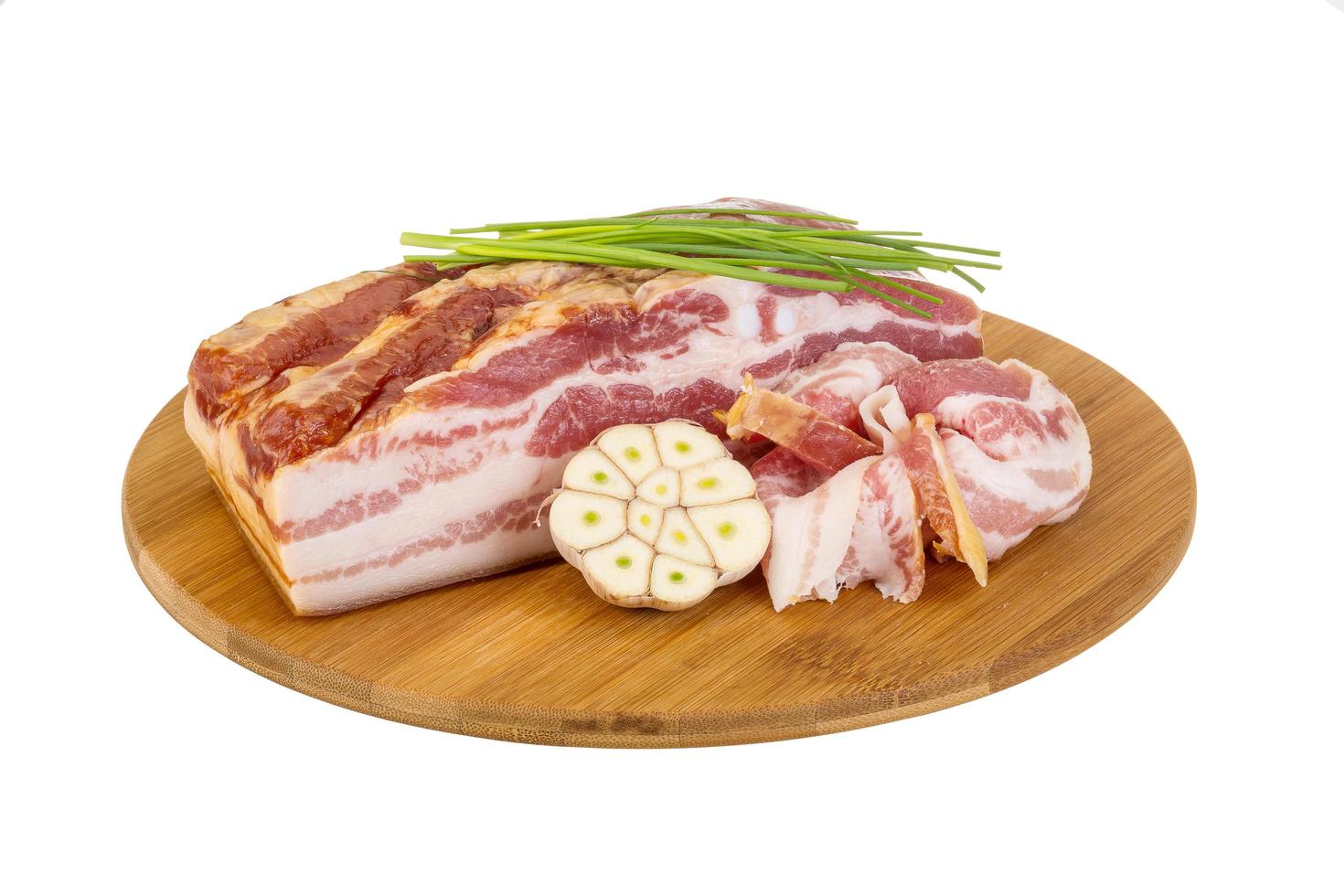 bacon na placa de madeira e fundo branco foto
