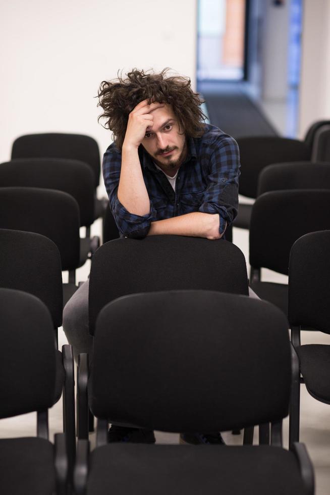 um aluno senta-se sozinho em uma sala de aula foto