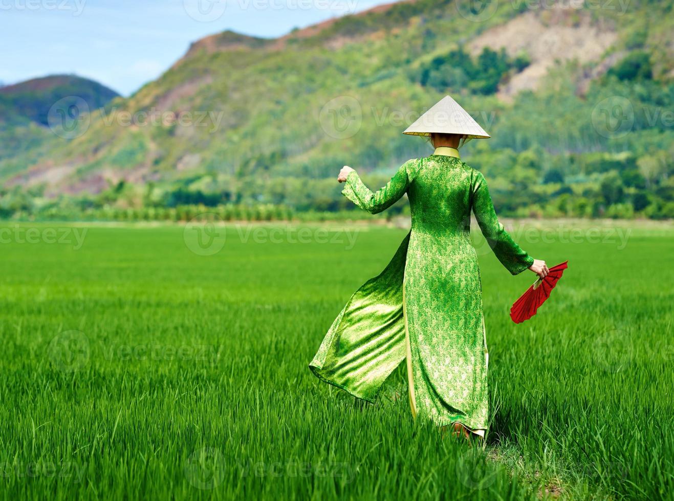mulher andando em um vestido longo tradicional de campo de arroz foto