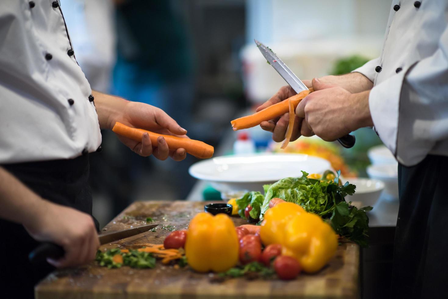 mãos de chefs cortando cenouras foto