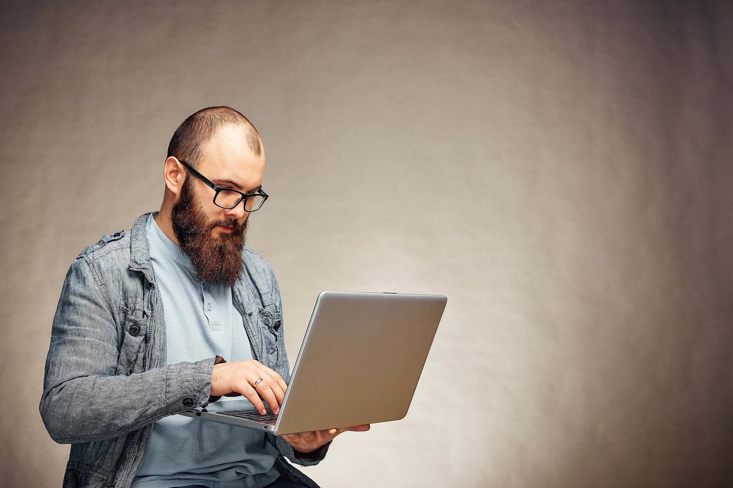 homem freelancer bem sucedido estilo de vida com barba atinge novo objetivo com laptop no interior do loft. foto