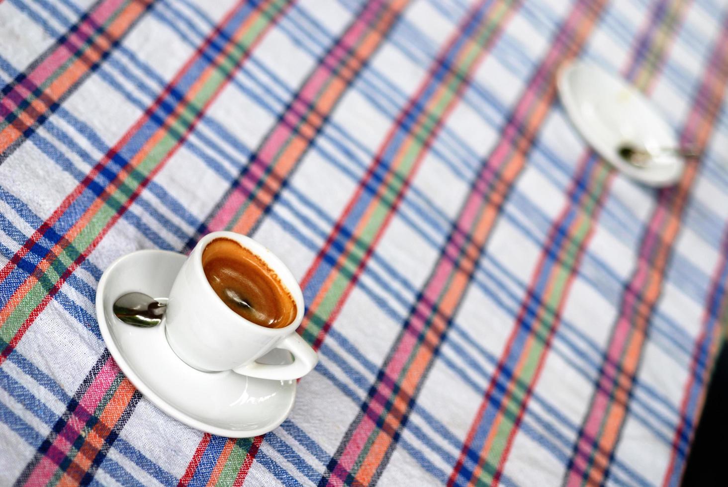 xícara de café em uma toalha de mesa colorida foto