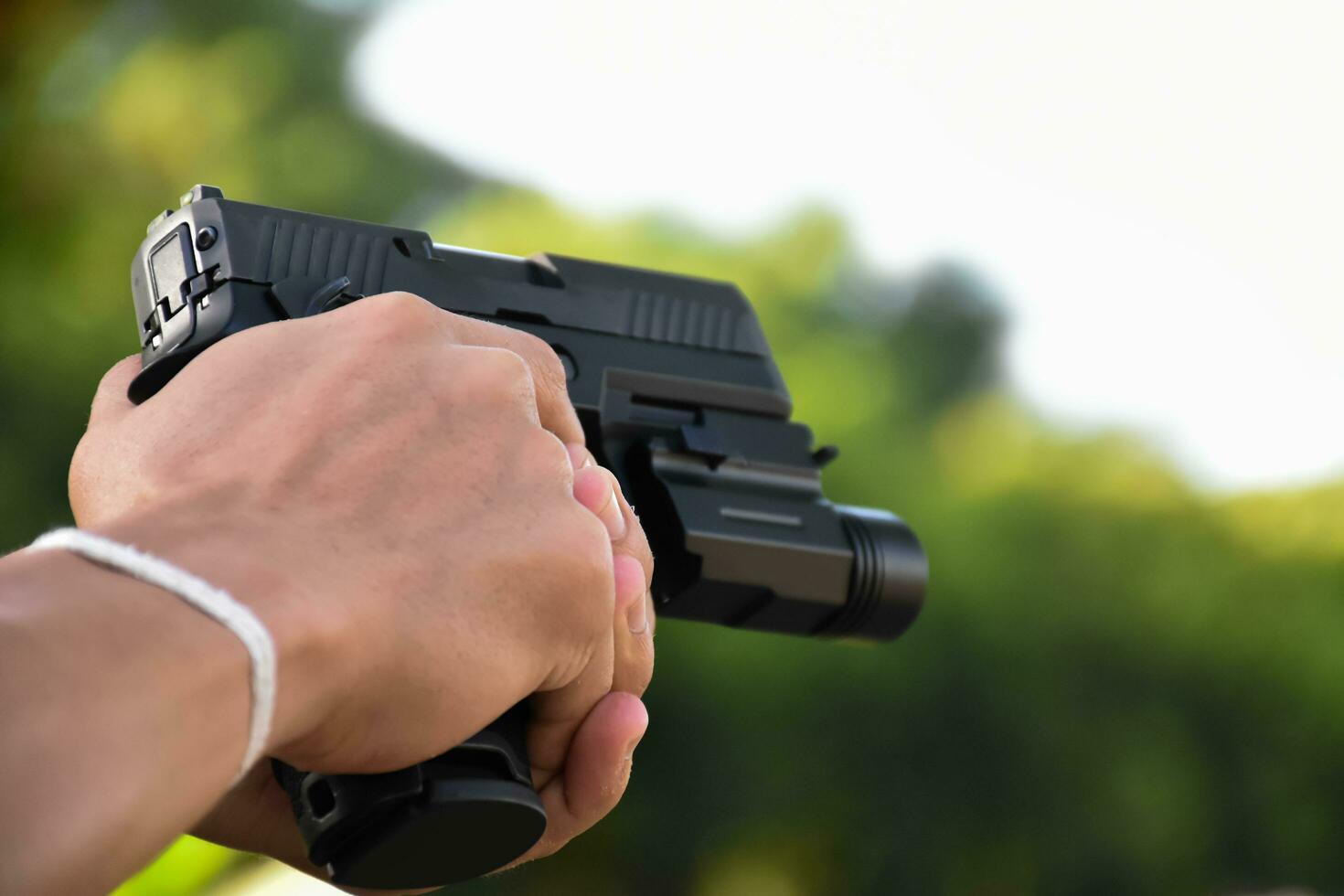 pistola segurando nas mãos do atirador no clube de tiro, foco suave e seletivo na pistola, conceito para tiro esportivo, guarda-costas, treinamento de segurança, máfias, gângsteres e autoproteções. foto