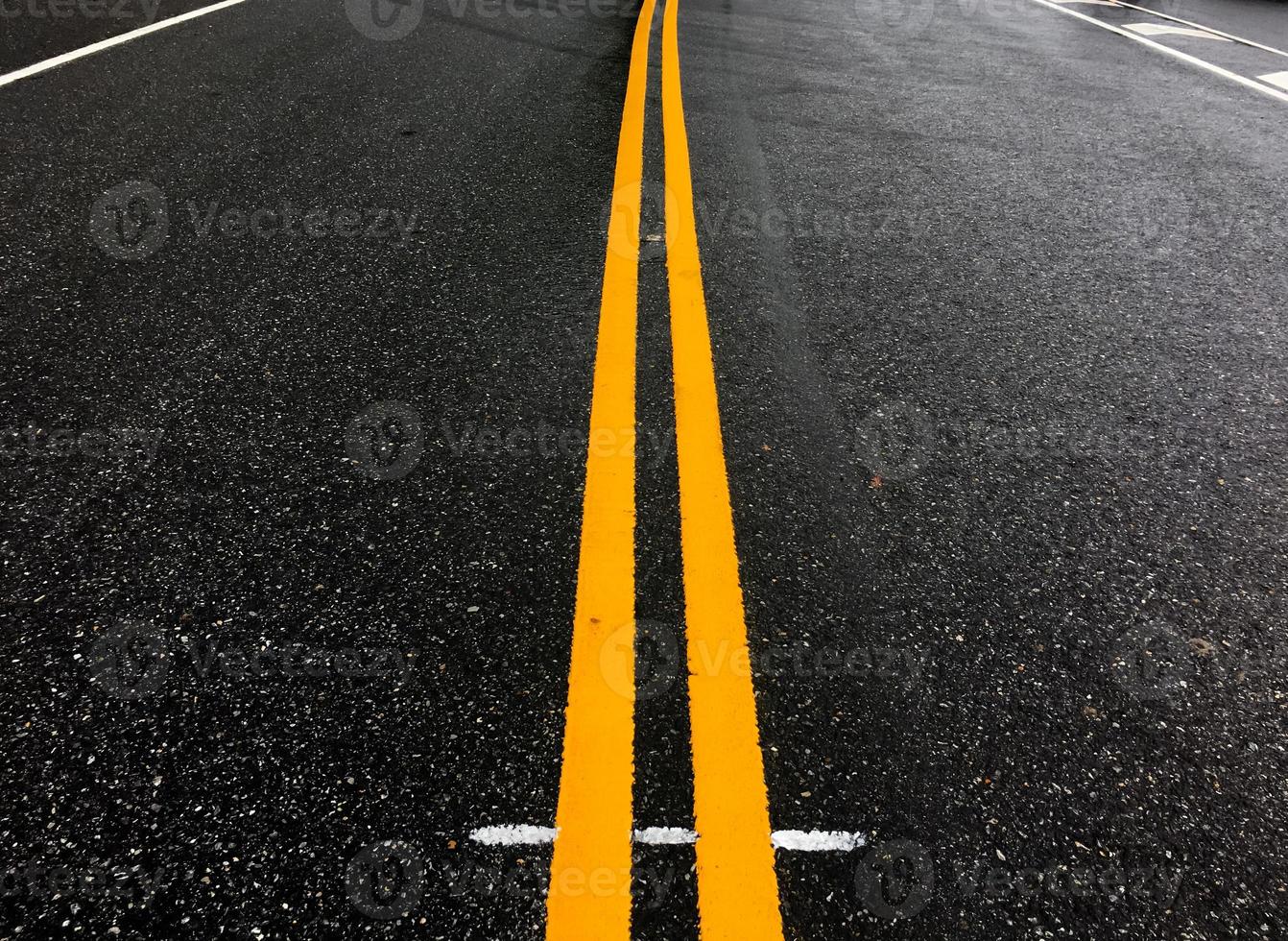 estrada de asfalto com linhas amarelas à noite do dia com carros vazios, foco suave e seletivo. foto