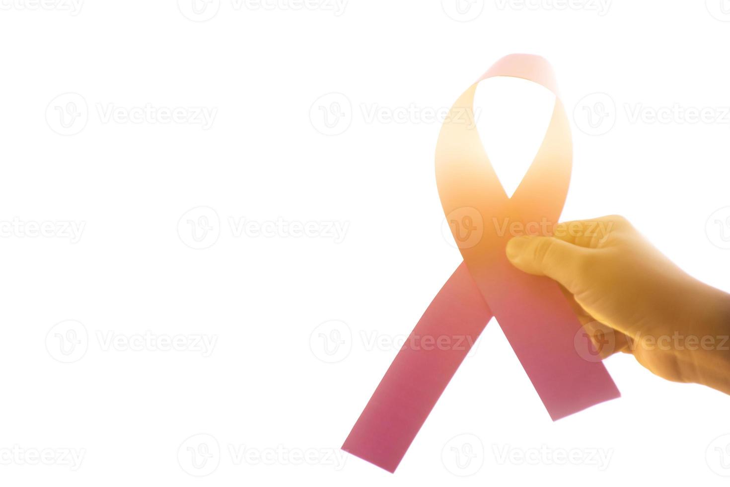 fita de papel rosa segurando nas mãos de uma adolescente para mostrar e chamar todas as pessoas ao redor do mundo para apoiar e participar da campanha de câncer de mama da mulher, foco suave e seletivo. foto
