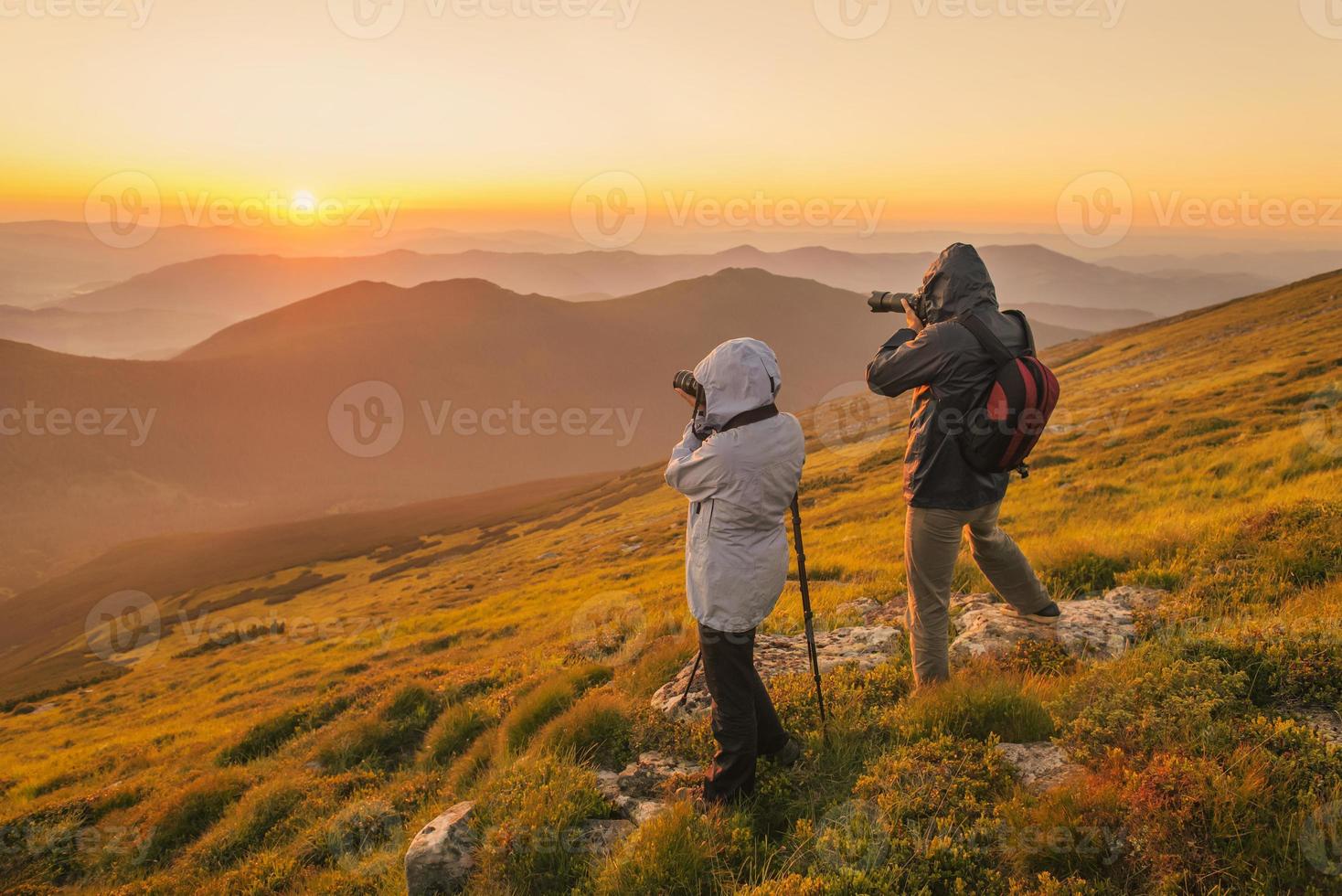 fotógrafos leva um pôr do sol nas montanhas foto