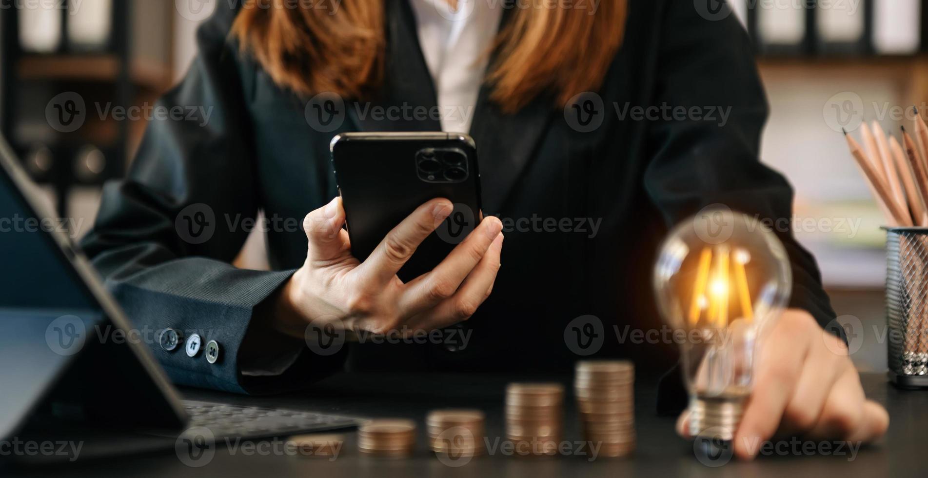 mão de negócios segurando o telefone inteligente mostrando estratégia de negócios criativa com lâmpada como conceito no escritório foto