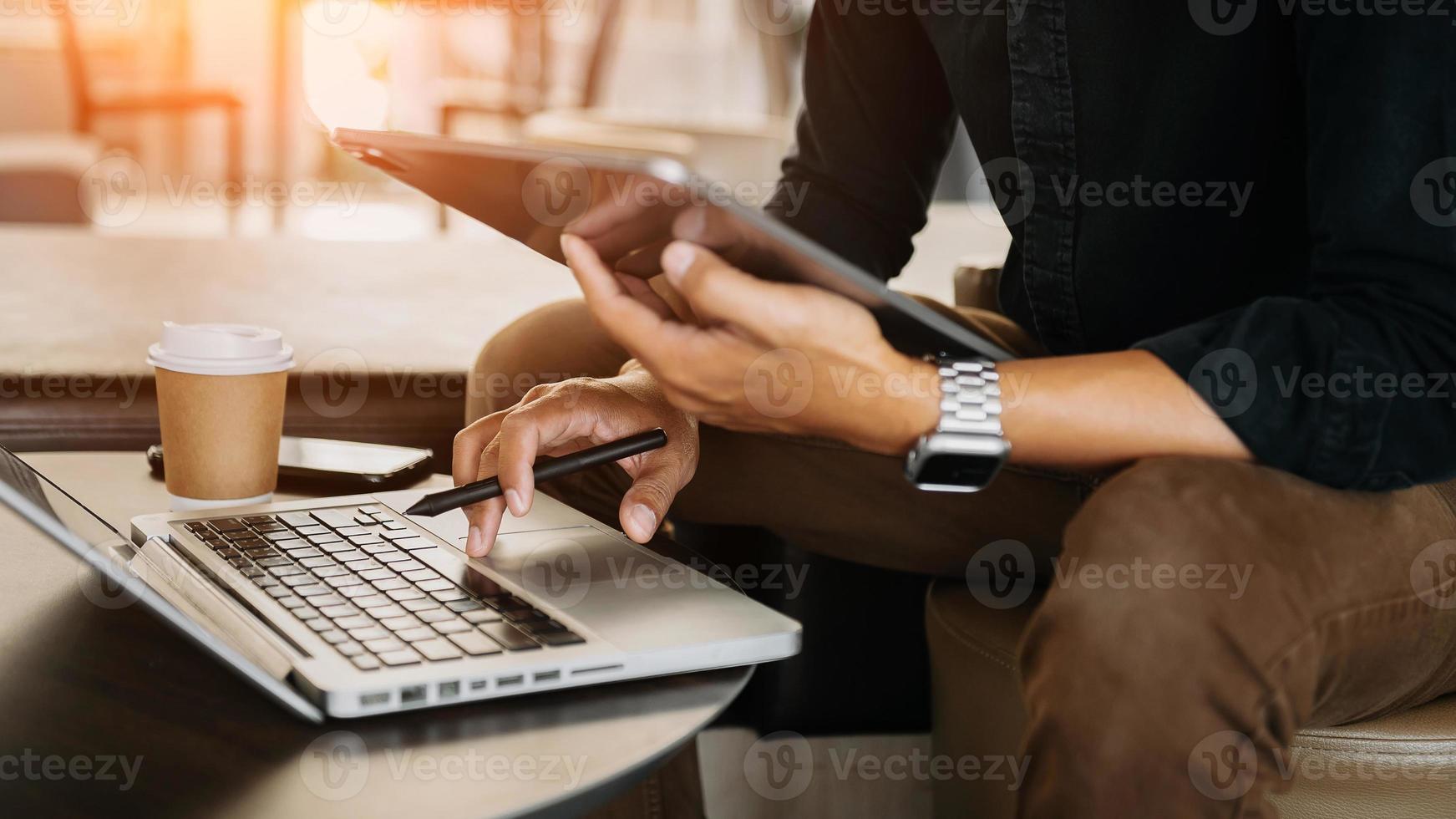 mão de empresário usando laptop de telefone inteligente e tablet com diagrama de rede social na mesa como conceito na luz da manhã. foto