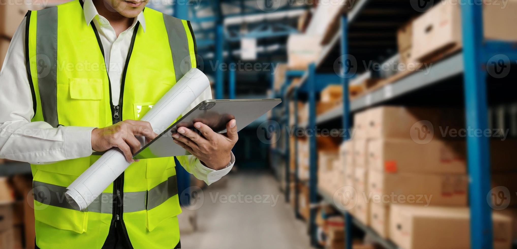 trabalhador de armazenamento de uniforme usando capacete verifica estoque e inventário com computador tablet digital no armazém de varejo cheio de prateleiras com mercadorias. foto