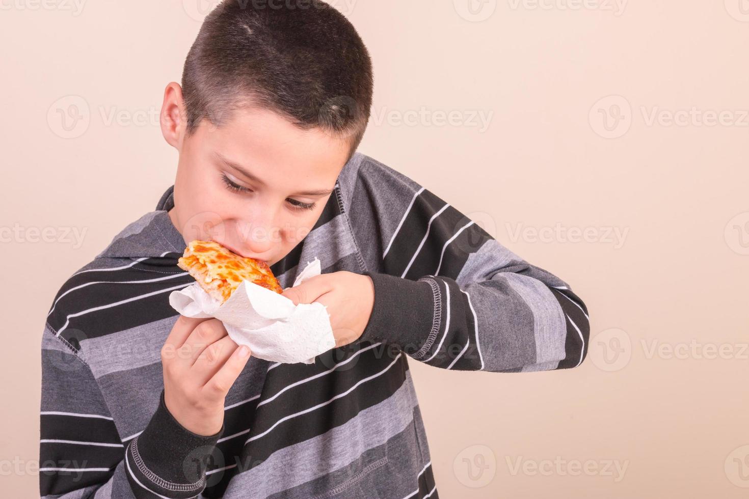 garoto comendo pizza foto