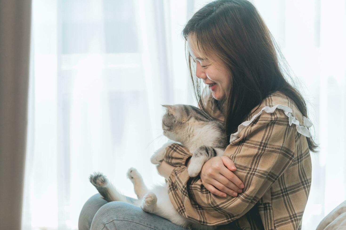 retrato de jovem segurando gato fofo. fêmea abraçando seu gatinho fofo de cabelo comprido. plano de fundo, copie o espaço, feche. adorável conceito de animal de estimação doméstico. foto