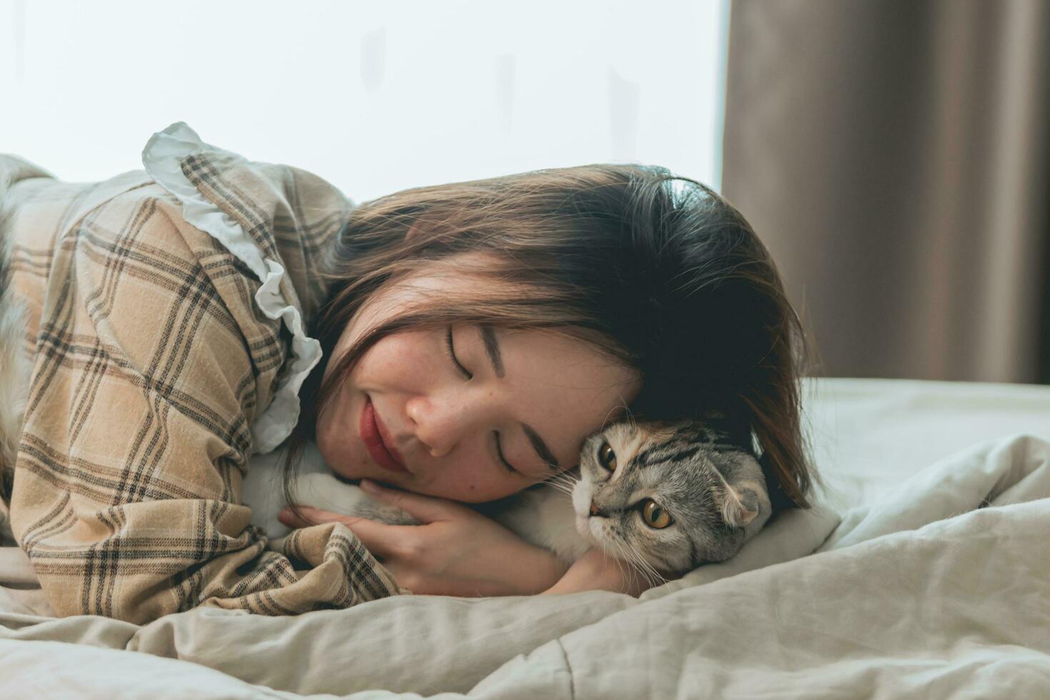 mulher asiática brincando e abraçando com gato foto