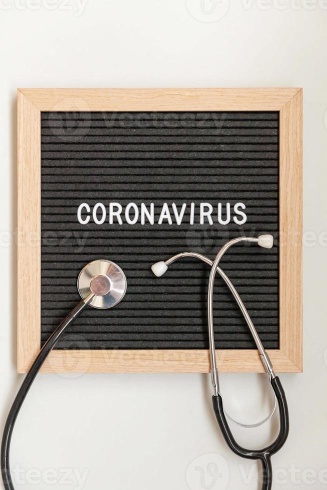 frase de texto coronavírus e estetoscópio no fundo do quadro de letras pretas. novo coronavírus 2019-ncov, mers-cov síndrome respiratória do oriente médio coronavírus originário de wuhan china foto