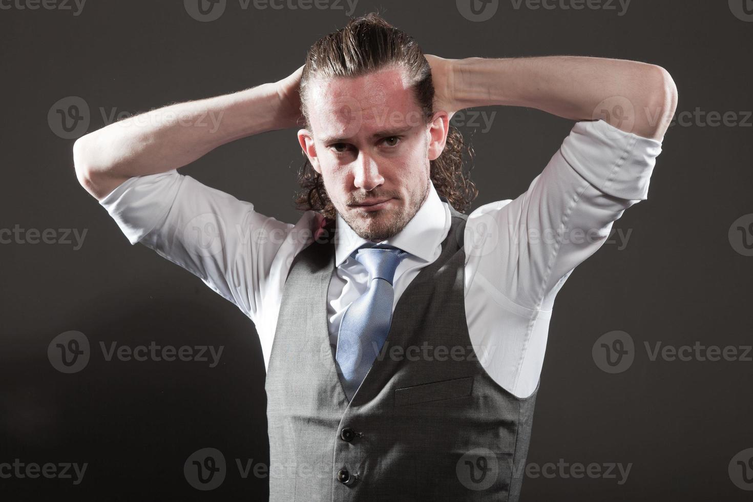 jovem rosto expressivo de cabelos longos, vestindo terno e gravata. foto