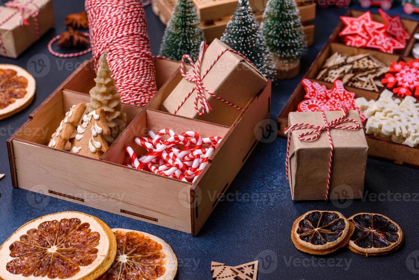 brinquedos de madeira da árvore de natal nas cores brancas e vermelhas, pão de gengibre e fatias secas de limão e toranja foto