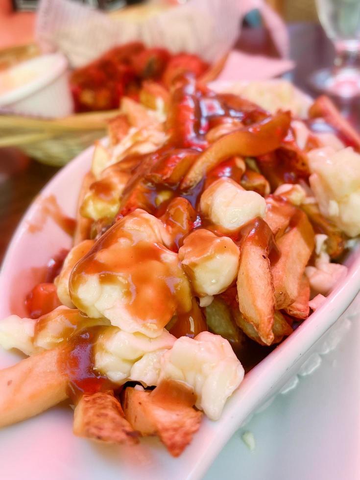 delicioso poutine com molho em um restaurante foto