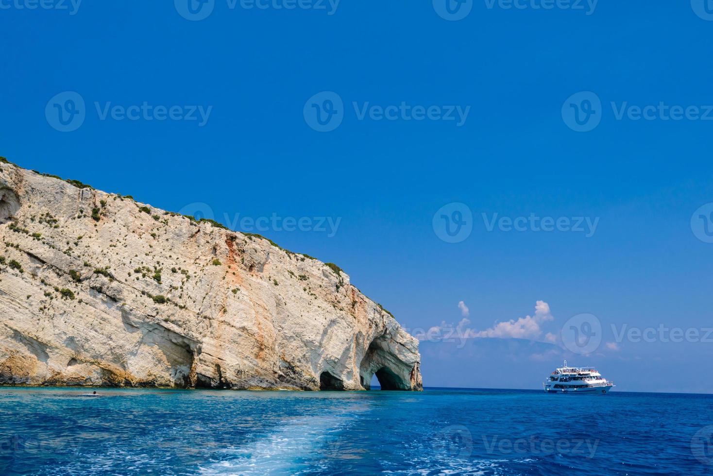 costa rochosa, caverna, mar e navio foto