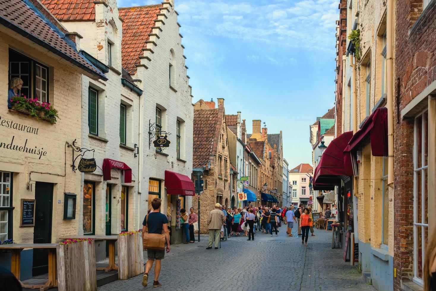 bruges, bélgica - 19 de setembro de 2014. restaurante na cidade velha de bruges. muita gente de grupos turísticos andando na rua. foto