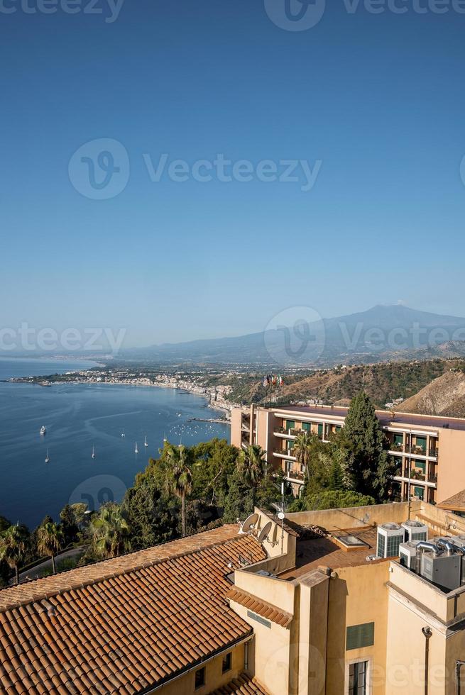 cenário idílico do hotel elios e monte etna pela paisagem marítima com céu ao fundo foto