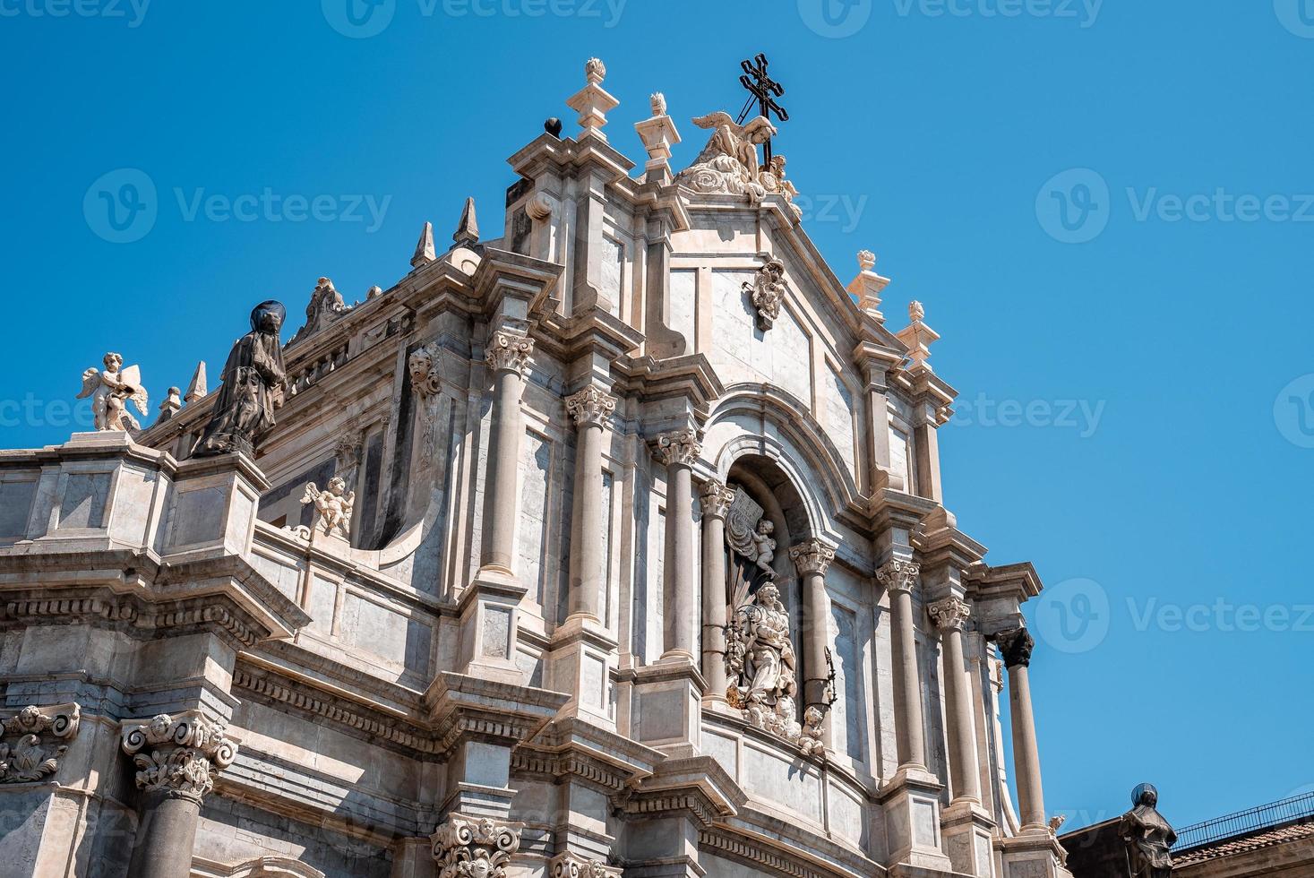 vista de ângulo baixo da fachada da catedral de catania com céu azul no fundo no verão foto