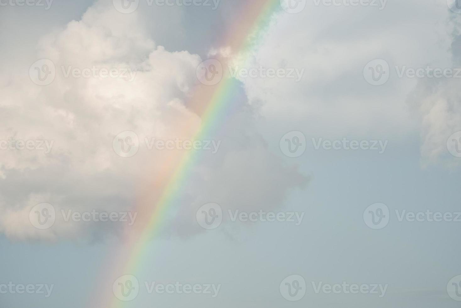 vista idílica do arco-íris em meio ao céu nublado em dia ensolarado foto