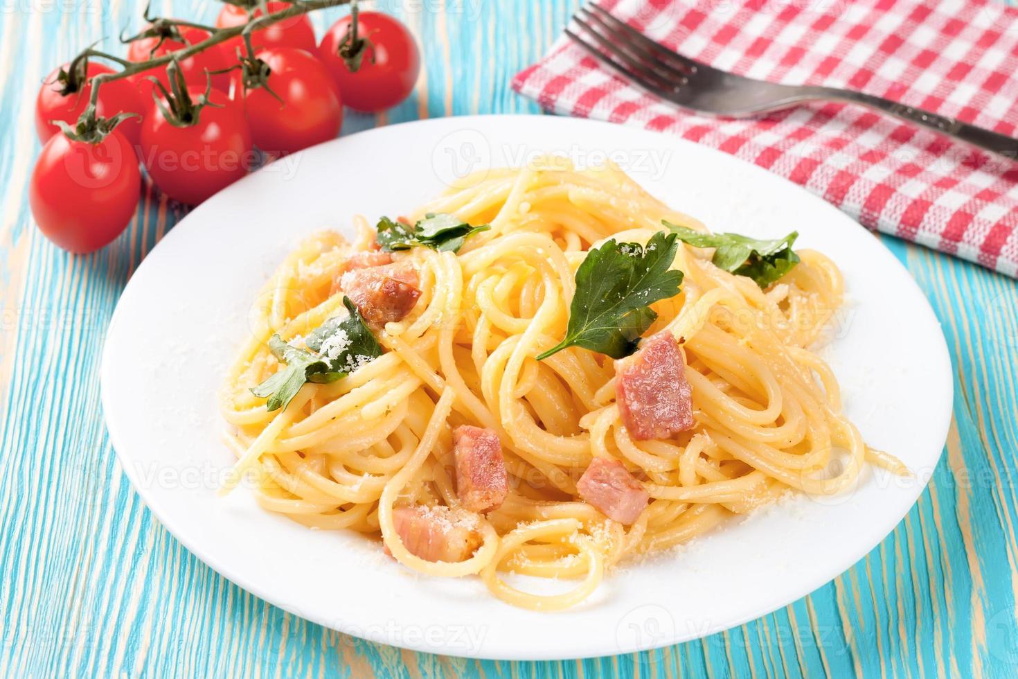 macarrão carbonara servido em um prato branco. foto