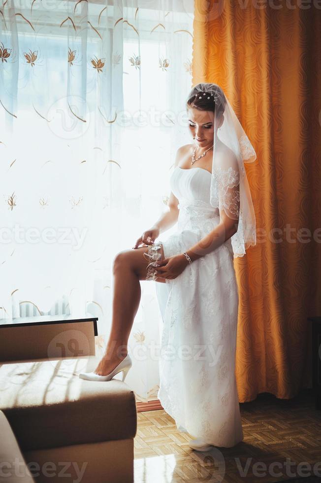 noiva linda se preparando no vestido de casamento branco com penteado foto